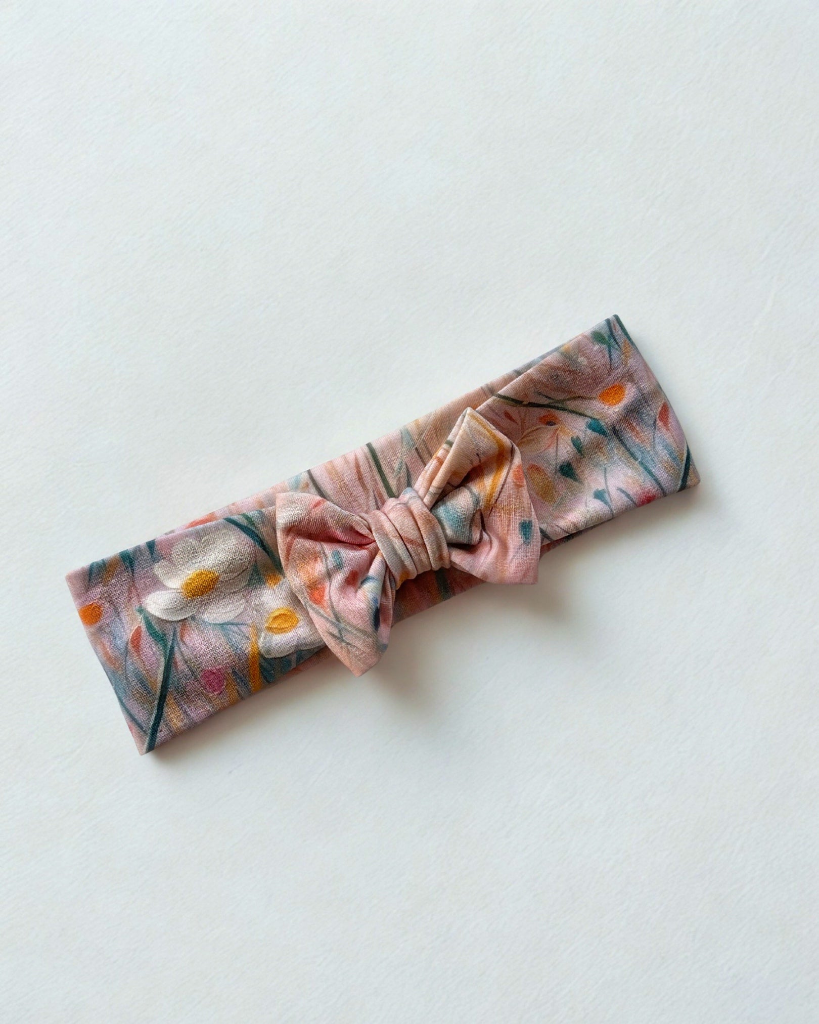 Opaska z kokardą w różowe kwiaty na łące