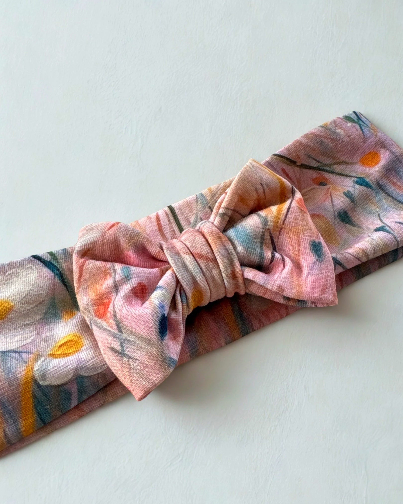 Opaska z kokardą w różowe kwiaty na łące